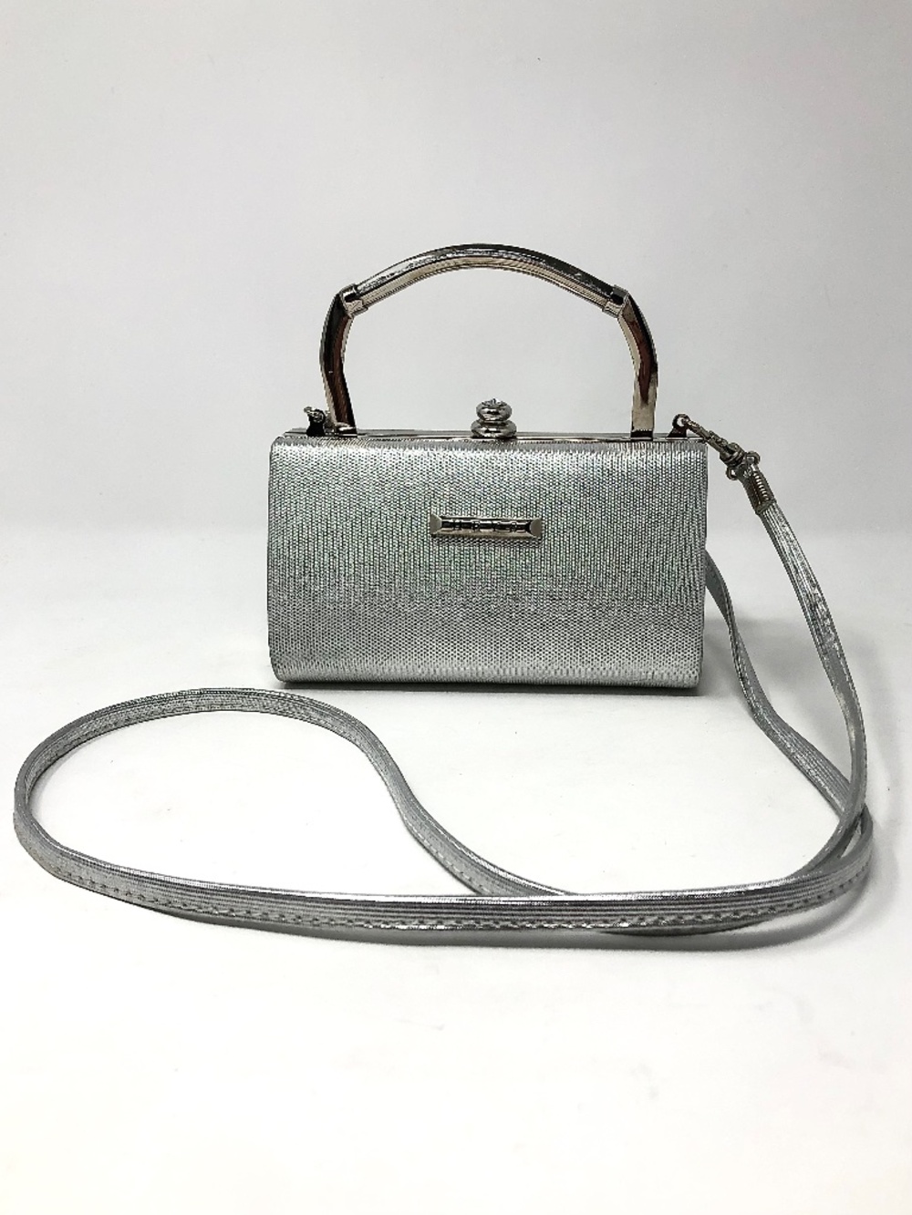 HEYS Y2K metallic silver hard shell clutch bag with detached cross body strap